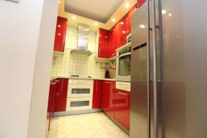 a kitchen with red cabinets and a stainless steel refrigerator at Apartment Društveni dom I in Sarajevo