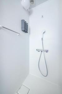 a white bathroom with a shower with a hose at ぷふか浅草 in Tokyo +55 photos