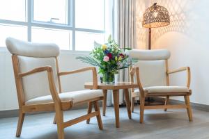 two chairs and a table with a vase of flowers at Beach Walk Boutique Jumeirah in Dubai