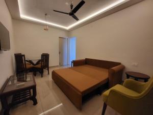 a room with a bed and a couch and a table at Palm Crest The Colva Diaries in Colva