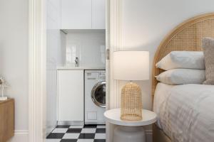 1 Schlafzimmer mit einem Bett, einer Waschmaschine und einem Trockner in der Unterkunft Boutique Studio with Balcony in Perfect Location in Sydney