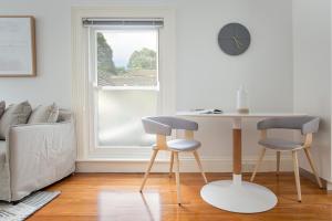 einen Tisch und zwei Stühle in einem Zimmer mit Fenster in der Unterkunft Boutique Studio with Balcony in Perfect Location in Sydney