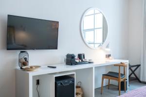 a room with a white desk with a tv on a wall at Beach Walk Boutique Jumeirah in Dubai