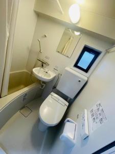a small bathroom with a toilet and a sink at LIONS YONEGAHAMA l 米が浜通 in Yokosuka