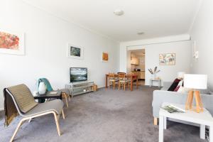 ein Wohnzimmer mit einem Sofa und einem Tisch in der Unterkunft Chic Unit with Rooftop Terrace near Sights & Shops in Sydney