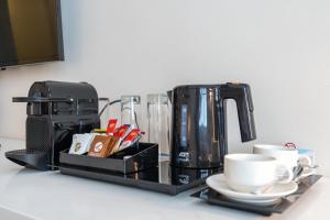 a counter with a coffee maker and cups on it at Beach Walk Boutique Jumeirah in Dubai
