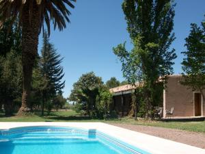 a swimming pool in front of a house with trees at Posada Cavieres Wine Farm in Maipú