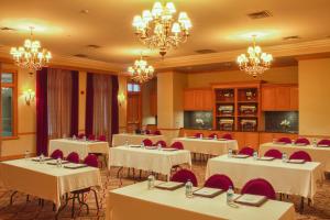 uma sala de jantar com mesas, cadeiras e lustres em Carlton Hotel em Atascadero