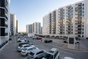 een parkeerplaats met auto's geparkeerd voor hoge gebouwen bij 1 Bedroom Apartment Yas Island in Abu Dhabi