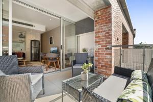 uma sala de estar aberta com uma parede de tijolos em Designer 2-Bed Unit with Balcony Metres from Beach em Melbourne