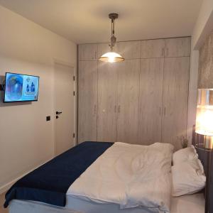 a bedroom with a large bed and a light fixture at Nereide Apartament - Complex Infinity Pool in Mamaia Nord +10 photos