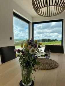 Un jarrón lleno de flores sobre una mesa. en PanoramaChalet Winterberg, en Winterberg