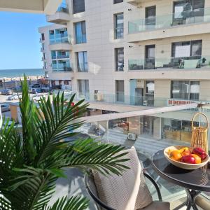 a bowl of fruit sitting on a table on a balcony at Nereide Apartament - Complex Infinity Pool in Mamaia Nord