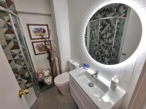Un baño con lavabo, inodoro y espejo. en Kyra House Centro Vigo, en Vigo