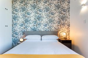 una camera da letto con un letto e carta da parati blu e bianca di Comfy Balcony Studio near Parks, Shopping & Dining a Sydney