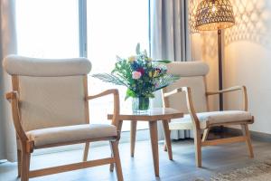 two chairs and a table with a vase of flowers at Beach Walk Boutique Jumeirah in Dubai