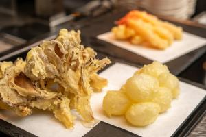 dois pratos brancos de alimentos com carne e batatas em KAMENOI HOTEL Kusatsu Yubatake em Kusatsu