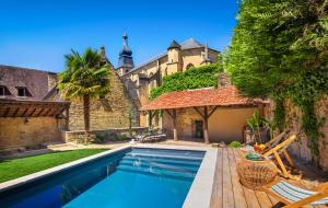 a swimming pool in the backyard of a house at Maison des Chanoines in Sarlat-la-Canéda
