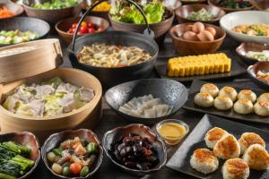 a table topped with bowls of different types of food at KAMENOI HOTEL Kusatsu Yubatake in Kusatsu