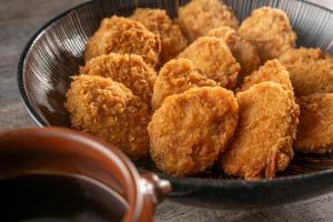 a bowl of fried food with a bowl of dipping sauce at KAMENOI HOTEL Kusatsu Yubatake in Kusatsu