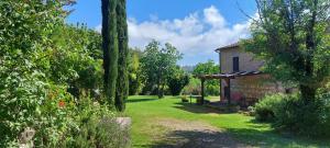 an old stone house with a garden and trees at Chiantishire Lovely Cottage with Garden & Parking! in Castelnuovo Berardenga