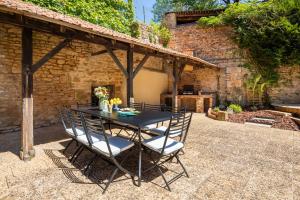 a patio with a black table and chairs at Maison des Chanoines in Sarlat-la-Canéda +102 photos