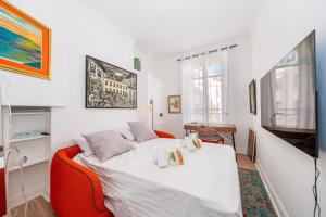 1 dormitorio con cama blanca y sofá rojo en L’app’Art Cannes - Contemporain Centre-Ville, en Cannes