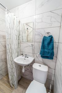 a white bathroom with a toilet and a sink at RUNČI in Lautere