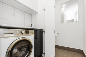 a white laundry room with a washer and dryer at Boutique Unit with Huge Terrace near Cafes & Shops in Kingston 