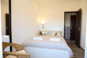 a bedroom with a white bed with pillows on it at Casa Sabino in Almádena