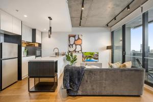 una cucina e un soggiorno con un grande divano di Modern, Executive 1 Bedroom Apartment With Balcony a Melbourne