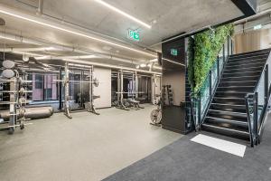 une salle de sport avec des tapis de course et un escalier dans un bâtiment dans l'établissement Modern, Executive 1 Bedroom Apartment With Balcony, à Melbourne