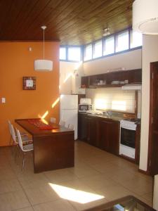 a large kitchen with a table and a refrigerator at Cabañas Klippen in Mar del Plata