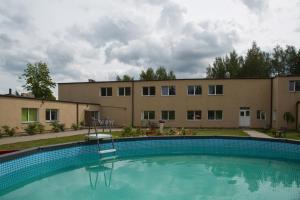 a large swimming pool in front of a building at VILLA ROZA Guest House in Rēzekne