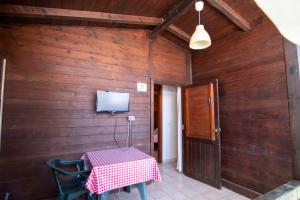 a dining room with a table and a tv at Villaggio Camping Esca in Marina di Camerota
