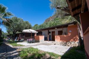 a table and an umbrella next to a building at Villaggio Camping Esca in Marina di Camerota