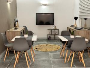 a living room with a table and chairs and a tv at Dilion Hotel in Parikia