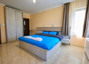 Un dormitorio con una cama azul con toallas. en Luxury Sea Villa - Kabalan 1 en Burgas