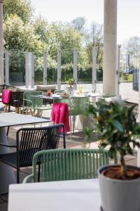 een patio met tafels en stoelen en een potplant bij Mercure Tallinn in Tallinn