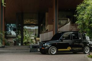 ein schwarzes Auto, das vor einem Gebäude geparkt ist in der Unterkunft Richmann Resort Hotel Hatyai in Hat Yai