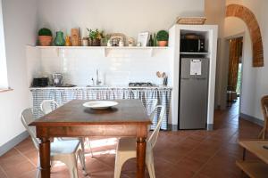 cocina con mesa de madera y nevera en Agriturismo Bella Valle - Podere Bellavista 1, en Castiglioncello