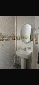 La salle de bains blanche est pourvue d'un lavabo et d'un miroir. dans l'établissement BAFFOUR APARTMENTS, à Adiebaba