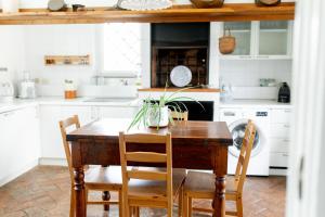 een keuken met een houten tafel en stoelen bij Villa con pascina panoramica in Bracciano