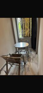 a table and two chairs and a table and a window at BAFFOUR APARTMENTS in Adiebaba