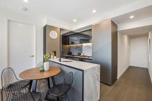 a kitchen with a counter and a table and chairs at Impeccably Styled 2-bedroom CBD Apartment in Melbourne