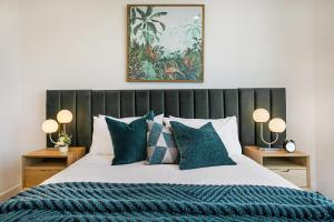 a bedroom with a large bed with blue pillows at Impeccably Styled 2-bedroom CBD Apartment in Melbourne