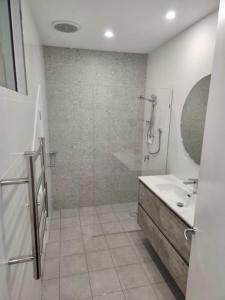 a bathroom with a shower and a sink and a mirror at Beautiful 2-Storey Unit with Balcony near Smith St in Melbourne