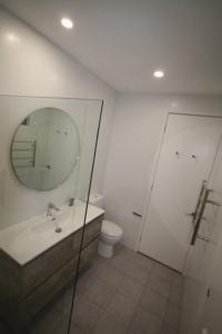 La salle de bains est pourvue d'un lavabo, d'un miroir et de toilettes. dans l'établissement Beautiful 2-Storey Unit with Balcony near Smith St, à Melbourne