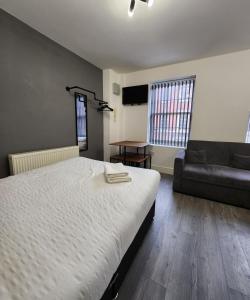 sypialnia z dużym łóżkiem i kanapą w obiekcie Cosy Chic Studio in Central Liverpool w Liverpoolu