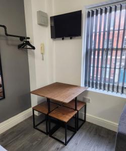 stół i ławka w pokoju z oknem w obiekcie Cosy Chic Studio in Central Liverpool w Liverpoolu